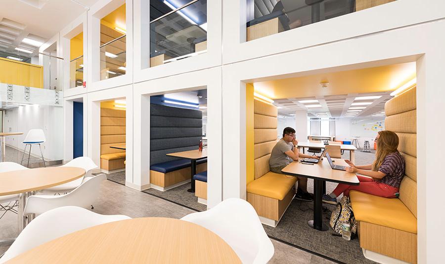 Two students studying at a table in a library at the University of Rochester